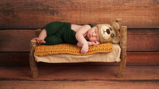 刚出生的婴儿睡在一张小床上4k超高清壁纸和背景