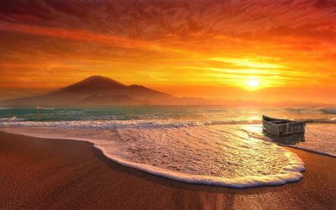 在日落时分的海滩上船壁纸和背景图像